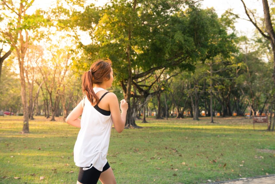 Someone running in a park with trees in the back