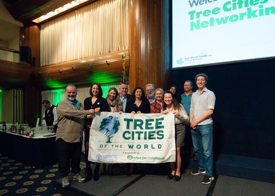 Trees for Cities staff and others who have taken part in Tree Cities of the World holding up a banner