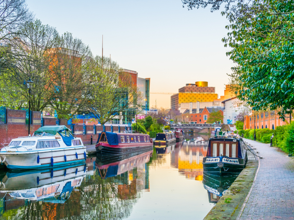 Sunset view of brick buildings alongside a water channel in the central Birmingham, England