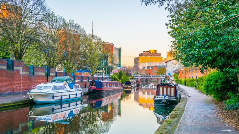 Sunset view of brick buildings alongside a water channel in the central Birmingham, England