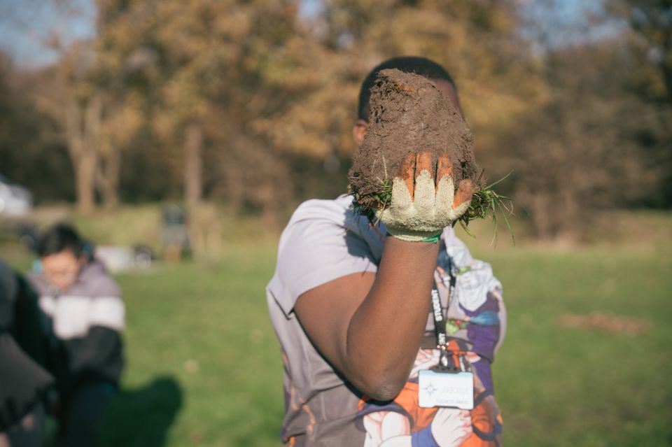 a young person holding up a clod of soil